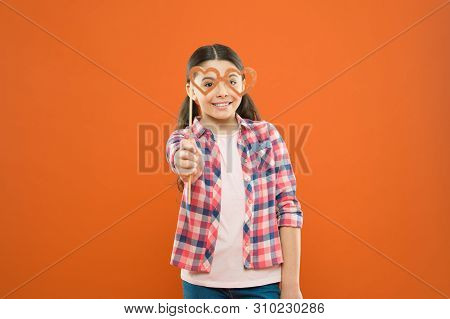 Fun Valentines Props. Cute Kid Smiling With Fancy Party Props On Orange Background. Funny Small Girl