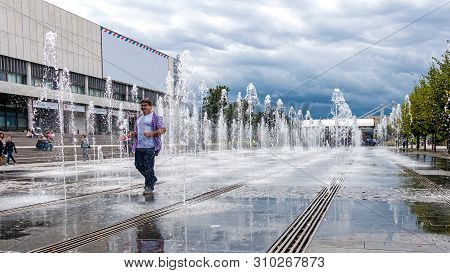 Moscow,museon Park,september 4,2016: Smiling Adult Man Are Walking Between The Jets Of Water In The 