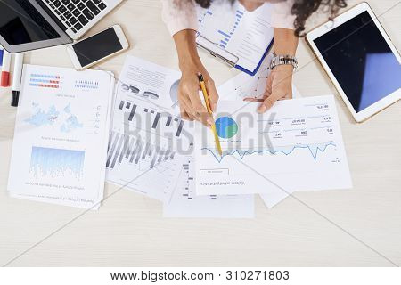 Hands Of Female Financial Manager Analyzing Various Charts Graphs And Finanacial Reports On Her Tabl