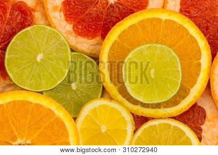 Four Slices Of Citrus Fruits, Closeup Background.