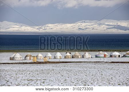 Yurt Town On The Shore Of Son-kul Lake On The Background Of Snow-capped Mountains. Travel. Kyrgyzsta