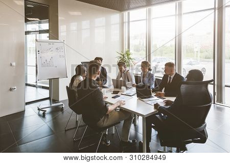 A Team Of Young Businessmen Working And Communicating Together In An Office. Corporate Businessteam 