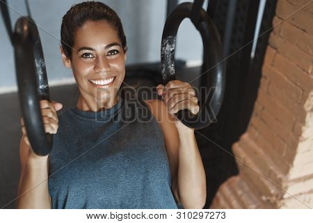 Close-up Satisfied Sweaty Attractive Smiling Woman Doing Crossfit Gymnastic Rings Exercise Push-ups,