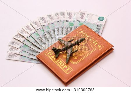Russian Money And Passport On White Background, Close-up, Passport And Money Fan In Hand. Travel Age