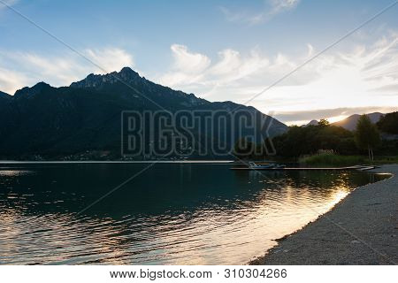 Sunset Over Lago Di Ledro, Trento, Italy. Landing Pier With Boats On The Foreground