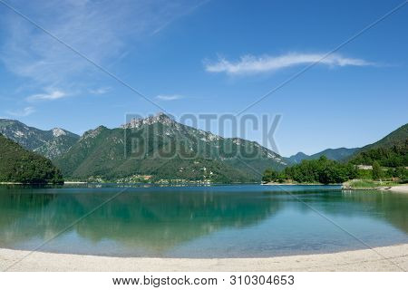 Lake Ledro With Mountains Reflecting In The Water. Trento, Italy
