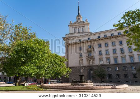 Sofia, Bulgaria - May 3, 2019: Fountain At Atanas Burov Square With  
 National Assembly At Backgrou