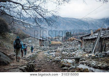 A Group Of Trekkers Heading To Samagau Village On Manaslu Circuit With View Of Mount Manaslu Range (