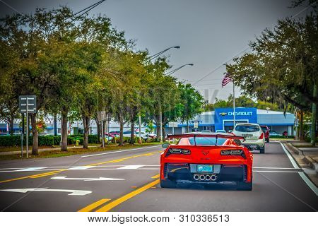 Florida, Usa - February 24, 2019: Red Corvette Seen From Behind With Chevrolet Dealership On The Bac