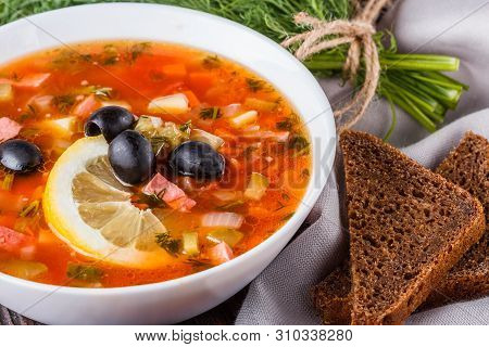 Traditional Russian Meat Soup Solyanka In Bowl On Rustic Wooden Table