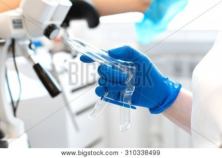 The Gynecologist Holds In His Hand A Mirror For Vaginal Examination Of The Patient.