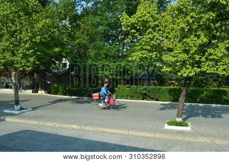 Wonsan, North Korea - May 3, 2019: Local Woman On A Bike Rides Along The Promenade Of The Japanese O