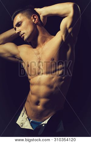 Young Handsome Man With Bare Torso And Sexy Muscular Body In Trausers In Studio