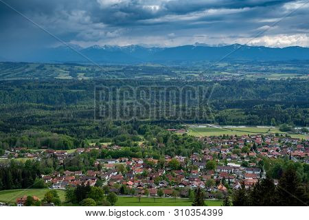 Hohenpeißenberg, Germany- May 19, 2019. Aerial View Of The Town Of Peissenberg With The Alps In The 