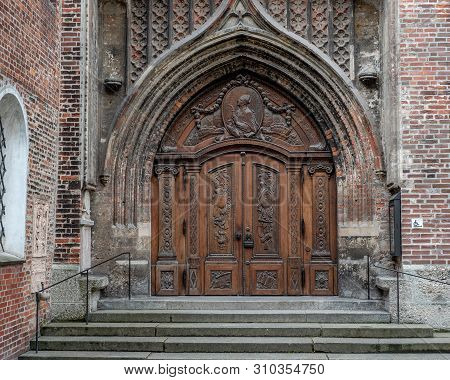 Munich, Bavaria, Germany - May 29, 2019. Door Outside Of Frauenkirche Viewed From Below Illustrating