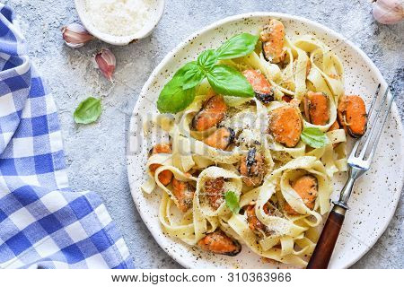 Tagliatella Pasta With Mussels And Cream Sauce On The Kitchen Table. View From Above.