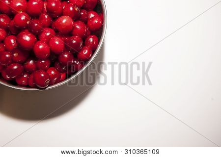 Bowl Of Cherries On A White Background. Red Cherries. Bowl Placed On The Top Left Corner Of The Fram