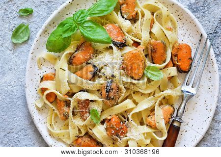Tagliatella Pasta With Mussels And Cream Sauce On The Kitchen Table. View From Above.