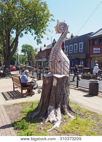 Formby, Merseyside, United Kingdom - 28 June 2019: People Crossing The Road And Sittong On Benches O