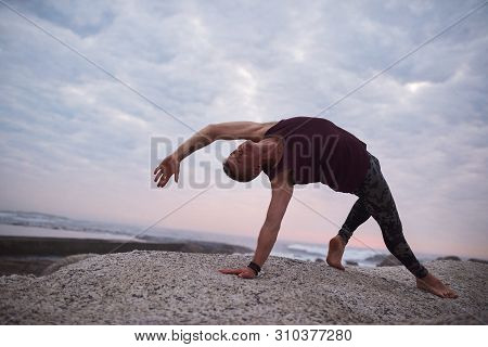Man Doing The Wild Thing Pose By The Ocean