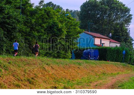 Rovigo, Italy - July, 2, 2019: people joging in Rovigo at sunset