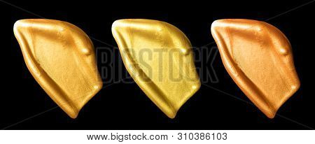 Creative brushstrokes of gold paint isolated on a black background. Gold paint texture.Acrylic gold paint. Smears of cosmetics, blush, highlighter, eye shadow, lipstick.