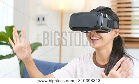 Young Beautiful Asian Woman Exciting In Vr Headset Looking Up And Trying To Touch Objects In Virtual