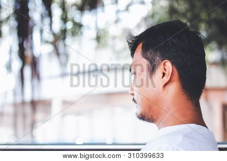A Lonely Man Sitting Back And Being Absent-minded Against Blurred Outdoor Background