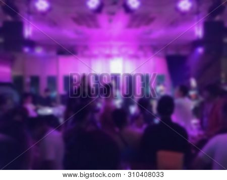 Blurred Crowd Of Enjoyment Peolple In Night Disco Club Background.