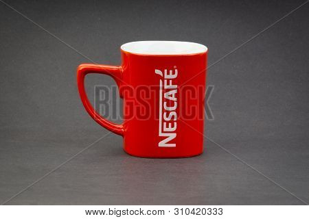 Kuala Lumpur, Malaysia - July 03, 2019; Promotional Red Nescafe Mug On Dark Background. Selective Fo