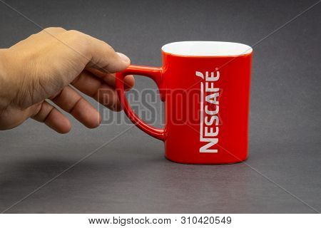 Kuala Lumpur, Malaysia - July 03, 2019; Promotional Red Nescafe Mug On Dark Background. Selective Fo