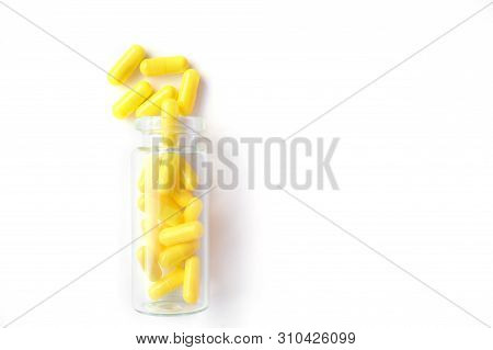 Yellow Capsules From Glass Bottle On White Background. Copyspace For Text. Epidemic, Painkillers, He
