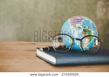 Education In Global World, Earth Globe Model Map And Glasses On Book . Concept Of Global Business St
