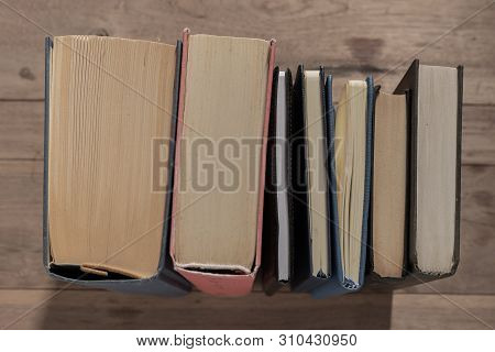 Lots Of Colourful Thick Open Books Stand On A Dark Background