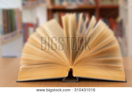 Book In Library With Old Open Textbook, Stack Piles Of Literature Text Archive On Reading Desk, And