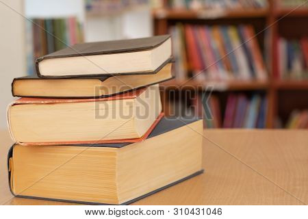 Book In Library With Old Open Textbook, Stack Piles Of Literature Text Archive On Reading Desk, And