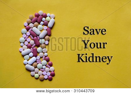 Medicine Pills Tablets Capsules In Shape Of Human Kidney In Yellow Background With Space For Text