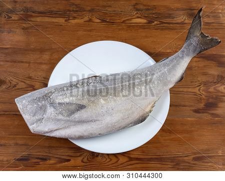 Frozen Carcass Of Saithe, Also Known As Coalfish Without Head On Dish On The Rustic Table, Top View