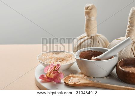 Clay And Sea Salt In Bowls On Marble Surface With Flower And Decora Isolated On Grey
