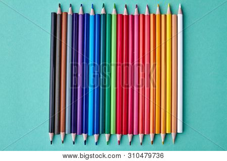 Set Of Sharp Crayons On Color Background. Set Of Multicolored Pencils On Colored Paper Background. T