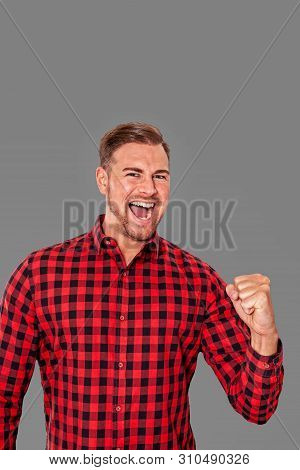 Motivated Enthusiastic Man Cheering And Pumping Air With His Fist In Exultation After A Person Succe