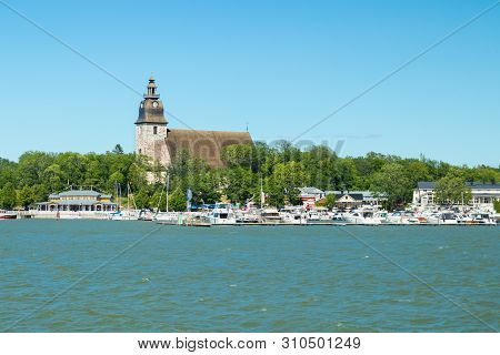 Naantali, Finland - 28 June, 2019: View From The Sea Of Naantali Harbor And Medieval Stone Church At
