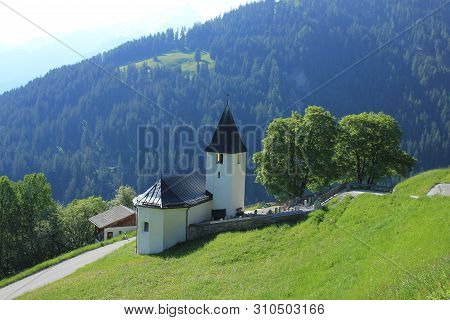 Church And Trees In Mutten, Canton Of Grisons, Switzerland.