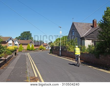 Formby, Merseyside, United Kingdom - 28 June 2019: A Man Riding A Bicycle Wearing A Reflective Vest 