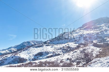 Sun On Top Of Snow Cover Himalaya Range. Frozen Rocky Peak Filled With Deep Snow Illuminate Rising S