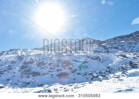 Sun On Top Of Snow Cover Himalaya Range. Frozen Rocky Peak Filled With Deep Snow Illuminate Rising S