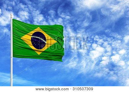 National Flag Of Brazil On A Flagpole In Front Of Blue Sky
