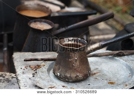 Boiling Coffee In Turkish Cezva On A Grate Over A Burning Bonfire, Camping Concept