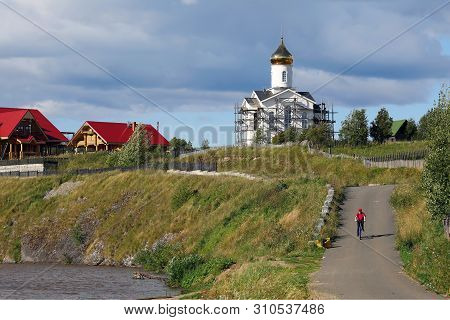 Visim, Russia - July 5, 2019. View Of The Village Road Along The Lake Bank And Church On A Hill. Vil