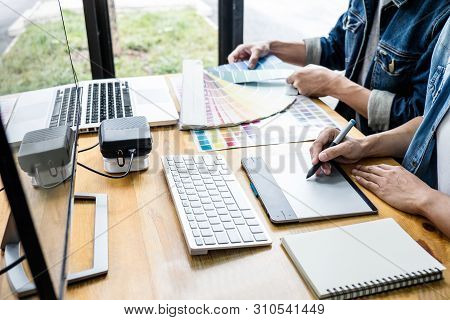Two Colleagues Creative Graphic Designer Working On Color Selection And Drawing On Graphics Tablet A